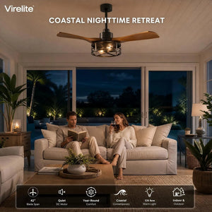 Couple relaxing on a sectional sofa under a VireLite 42-inch wood blade ceiling fan in a coastal living room at night, with warm E26 cage lights and pool views through the sliding glass doors.
