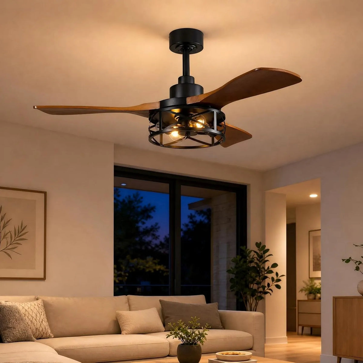 VireLite 42-inch black ceiling fan with three walnut wood blades and warm E26 cage lights glowing above a beige sofa in a modern living room at night.